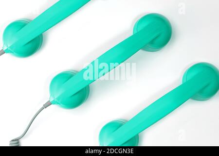 Muster aus neugrünem mintfarbenem Hörer eines Telefons auf weißem Hintergrund. Moderner Retro-Stil. Neue alte Technologie. Stockfoto