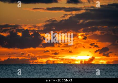 Sonnenuntergang am Meer. Landschaftsansicht der niedrigen Sonne geht über dem Meer mit bewölktem Himmel, in Großbritannien. Stockfoto