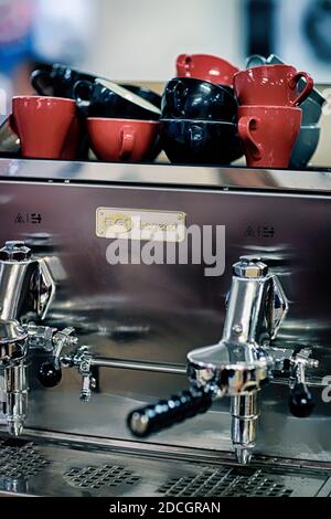 Im Café gab es viele rote Kaffeetassen aus Keramik auf der Espressomaschine. Selektiver Fokus. Kaffeetassen auf der Kaffeemaschine im Café Soft Focus select Stockfoto