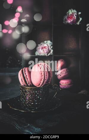 Traditionelle französische mehrfarbige Makkaroni in einer Holzkiste auf dem Tisch. Schöne romantische Dessert von Mandelkuchen. Stockfoto