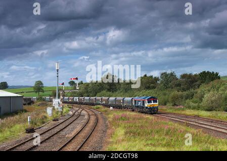 GB Railfeight Baureihe 66 Lokomotive 66747 vorbei Hellifield in der Aire Tal mit einem Güterzug von Zuschlagstofftrichtern Stockfoto