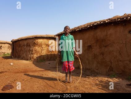 Maasai Junge springen Seil in seinem Dorf, Rift Valley Provinz, Maasai Mara, Kenia Stockfoto