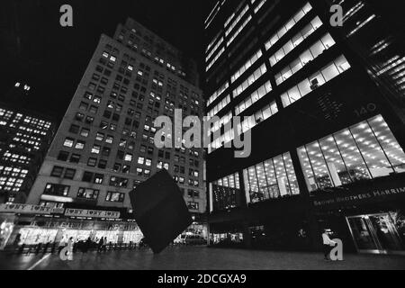 New York, USA - 30. November 2019. Nachtansicht mit Red Cube am Broadway, in der Innenstadt von Fidi Financial District, New York City. Schwarzweiß-Bild Stockfoto
