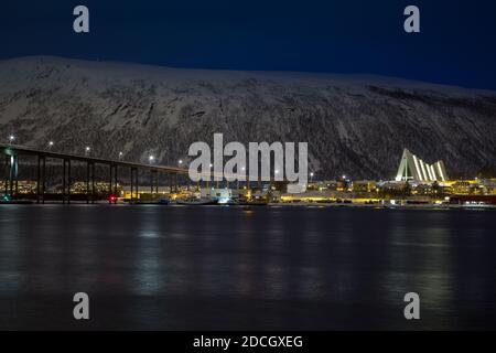 Nachtansicht von Tromsdalen und der beleuchteten arktischen Kathedrale von Tromsø im Winter. Stockfoto