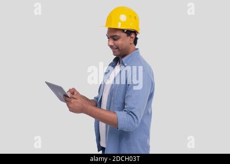 Bauarbeiter Tablet in den Händen halten. Mann Mit Tablet. Architect Holding Tablet. Gelber Harthelm. Arbeiter Isoliert Stockfoto
