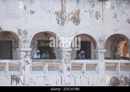 Männer, die aus dem Balkon schauen, im Palace Hotel, Lamu County, Lamu, Kenia Stockfoto