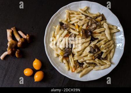 Cavatelli mit Pilzen und gelben Kirschtomaten. Hausgemachte Pasta Stockfoto