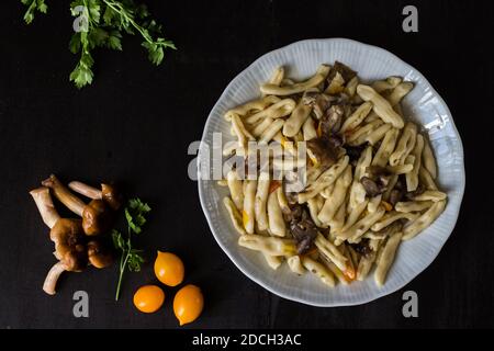 Cavatelli mit Pilzen und gelben Kirschtomaten. Hausgemachte Pasta Stockfoto