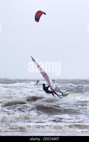 St. Peter Ording, Deutschland. November 2020. Ein Wind- und ein Kitesurfer trotzen Wind und Regen und genießen die Wellen. Quelle: Georg Wendt/dpa/Alamy Live News Stockfoto