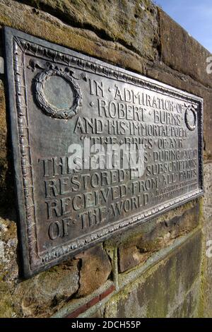 Metalltafel an Robert Burns auf der Auld Brig Ayr, Ayrshire, Schottland, die Worte sind "in Bewunderung von Robert Burns und seinem unsterblichen Gedicht die Brigs von Ayr. Diese Brig wurde im Jahr 1907-10 restauriert durch Abonnement aus allen Teilen der Welt erhalten. ' Stockfoto