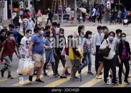 Hongkong, China. November 2020. Fußgänger mit Gesichtsmasken gehen über eine Straße in Hung Hom, Hongkong, Südchina, 21. November 2020. UM MIT "Hong Kongs tägliche COVID-19-Infektionen Hit 3-Monats-hoch" Credit: Wang Shen/Xinhua/Alamy Live News Stockfoto