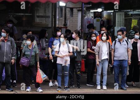 Hongkong, China. November 2020. Fußgänger mit Gesichtsmasken warten darauf, eine Straße in Hung Hom, Hongkong, Südchina, zu überqueren, 21. November 2020. UM MIT "Hong Kongs tägliche COVID-19-Infektionen Hit 3-Monats-hoch" Credit: Wang Shen/Xinhua/Alamy Live News Stockfoto