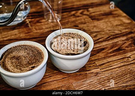 Tasse Verkoster Barista Gießen Sie heißes gekochtes Wasser in Tasse .Kaffee Schröpfen Verfahren. Stockfoto