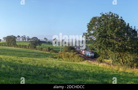 GB Railfeight Baureihe 66 Lokomotive 66747 Passing Coniston Cold in Das Aire-Tal mit einem Güterzug leerer Aggregate Trichter Stockfoto