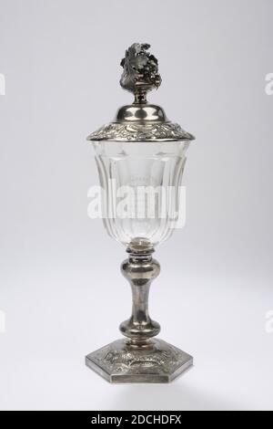 Kelch, Zilverfabriek J.M. van Kempen en Zn, Voorschoten, 1858, Silber, Glas, Schale und Deckel: 33.5 x 11,4 cm 335 x 114 mm, Schale: 24.3 x 11,6 cm 243 x 116 mm, Deckel: 9.5 x 11,4 cm 95 x 114 mm, Durchmesser Kelch: 10.4 cm / Durchmesser Boden: 11.3 cm, Kristallschale mit silbernem Deckel und silbernem Sockel. Der Kelch hat einen sechseckigen gewölbten Fuß, der oben mit Gravur und Verzahnung verziert ist und Blumen-, Blatt- und Ziermotive darstellt. Der silberne Stamm besteht aus einem scheibenförmigen Basisknoten, einem glatten Stamm und einem umgekehrten balusterförmigen Knoten. Der Kelchbecher ist aus dickem Glas gefertigt und in sechs Facetten geschnitten. Oben Stockfoto