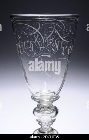 Glas, ca. 1700, Allgemein: 30.4 x 10,1cm 304 x 101mm, Glas aus farblosen Glas und mit Deckel. Das Glas hat eine leicht schräge gewölbte Basis mit einem profilierten Rand. Stahl mit Fußring und zwei hohlen Knoten, jeweils mit zwei Ringen unten und einem Ring oben. Ein flacher Ring um den Boden. Ziemlich schmaler Kelch mit schrägen Wand, auf dem Buchstaben graviert, die an gotische Schrift erinnern und von Locken umgeben sind: Vreede und Vryheit. Deckel mit breitem Rahmen und Rändelknopf mit Ring. Auf die Krümmung des Deckels in schrägen Kapitellen: AM BESTEN GEZWUNGEN. Der Deckel wird von zwei Halsbändern gekrönt, die von einem überragt werden Stockfoto