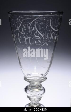 Glas, ca. 1700, Allgemein: 30.4 x 10,1cm 304 x 101mm, Glas aus farblosen Glas und mit Deckel. Das Glas hat eine leicht schräge gewölbte Basis mit einem profilierten Rand. Stahl mit Fußring und zwei hohlen Knoten, jeweils mit zwei Ringen unten und einem Ring oben. Ein flacher Ring um den Boden. Ziemlich schmaler Kelch mit schrägen Wand, auf dem Buchstaben graviert, die an gotische Schrift erinnern und von Locken umgeben sind: Vreede und Vryheit. Deckel mit breitem Rahmen und Rändelknopf mit Ring. Auf die Krümmung des Deckels in schrägen Kapitellen: AM BESTEN GEZWUNGEN. Der Deckel wird von zwei Halsbändern gekrönt, die von einem überragt werden Stockfoto