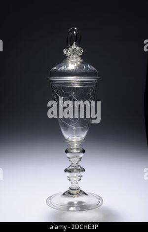 Glas, ca. 1700, Allgemein: 30.4 x 10,1cm 304 x 101mm, Glas aus farblosen Glas und mit Deckel. Das Glas hat eine leicht schräge gewölbte Basis mit einem profilierten Rand. Stahl mit Fußring und zwei hohlen Knoten, jeweils mit zwei Ringen unten und einem Ring oben. Ein flacher Ring um den Boden. Ziemlich schmaler Kelch mit schrägen Wand, auf dem Buchstaben graviert, die an gotische Schrift erinnern und von Locken umgeben sind: Vreede und Vryheit. Deckel mit breitem Rahmen und Rändelknopf mit Ring. Auf die Krümmung des Deckels in schrägen Kapitellen: AM BESTEN GEZWUNGEN. Der Deckel wird von zwei Halsbändern gekrönt, die von einem überragt werden Stockfoto