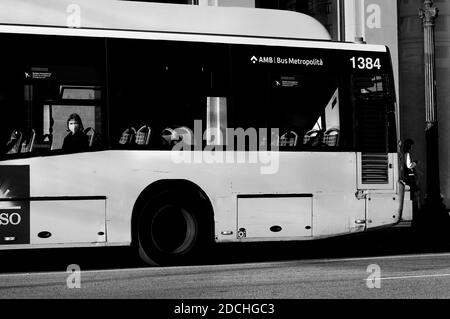 Frau mit Gesichtsmaske starrte aus dem Busfenster, Barcelona, Spanien. Stockfoto