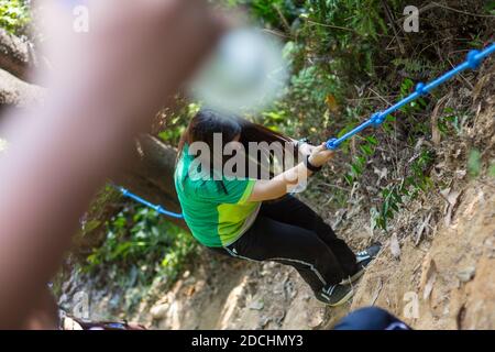 Ein Schulmädchen, das den Hügel hinaufklettert. Stockfoto