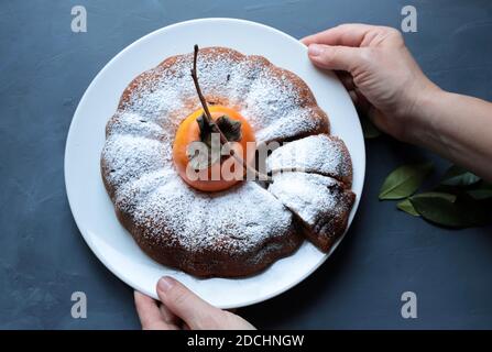 Hausgemachter Schokoladenkuchen mit Pimsimmon-Bündelkuchen mit Puderzucker isoliert auf grauem Hintergrund. Draufsicht. Stockfoto