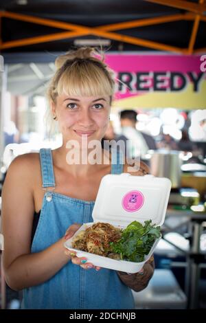 Großbritannien / England /London / Junge Frau, die vegane Lebensmittel auf dem Street Food Union Vegan Market verkauft Stockfoto