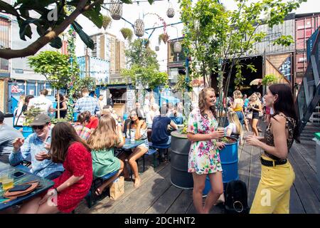 Menschen genießen Sie einen Drink in Brixton Pop, pop-up Container Bars und Restaurants in Brixton, London, UK Stockfoto