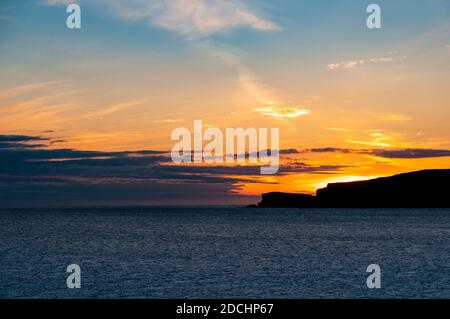 Der Sonnenuntergang hinter dem Vorgebirge von Creag A' Mhàil in Scourie Bay an der Nordwestküste Schottlands. Juni. Stockfoto