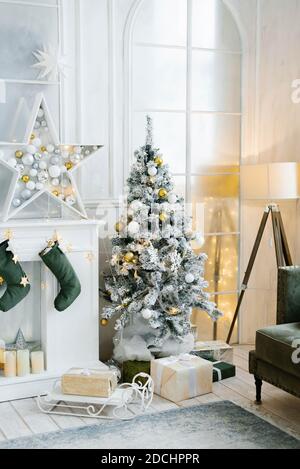 Eleganter schöner silberner Weihnachtsbaum mit weißen und goldenen Luftballons Im klassischen Wohnzimmer Stockfoto