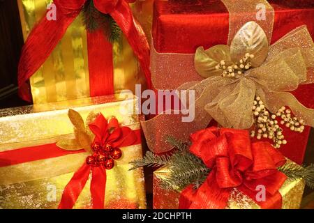 Schachteln von schön eingewickelten Weihnachtsgeschenken mit roten Bändern Stockfoto