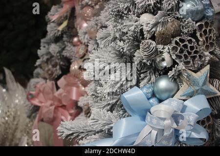 Geschmückter Weihnachtsbaum in babyblau und staubigen Rosenfarben. Silvesterszene. Selektiver Fokus Stockfoto