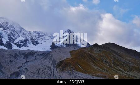 Panoramablick auf die Ostflanke des majestätischen Ortlergebirges in den Alpen mit Gletscher Suldenferner an einem bewölkten Herbsttag bei Sulden. Stockfoto