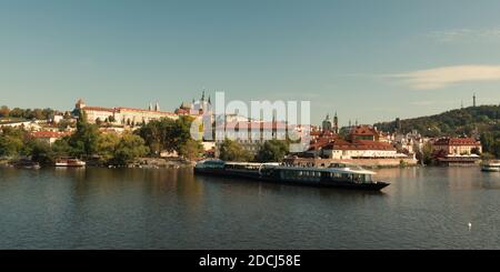 Ausflugsboot auf dem Moldausteg im Herbst. Blick auf Prag. Stockfoto