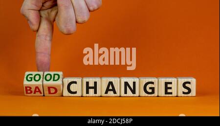 Männliche Hand dreht Würfel und ändert den Ausdruck "schlechte Änderungen" in "gute Änderungen". Schöner orangefarbener Hintergrund. Speicherplatz kopieren. Stockfoto