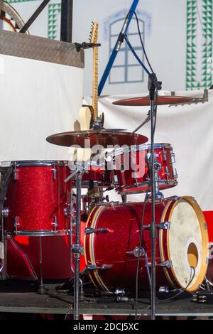 Rote Trommel auf der Bühne vor einem Konzert mit einem elektrischen Gitarre im Hintergrund Stockfoto