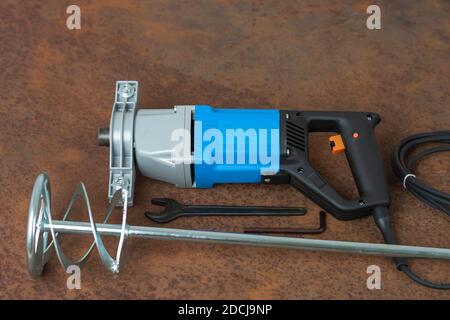 Schraubenschlüssel, Spiral Paddle Mischer und Mischbohrer zum Mischen von Mörtel, Farbe, Putz und Pulver auf alten rostigen Blech. Stockfoto