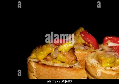 Gegrilltes Brot mit Guacamole (Avocado, rote Zwiebeln, Kirschtomaten, Pfeffer, Öl, Salz, Zitronensaft) Stockfoto