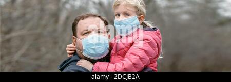 Vater und Kind Mädchen tragen schützende Gesichtsmasken im Freien. Familie Vater und Tochter schützen sich vor der Ausbreitung des Virus. Coronavirus COVID-19 loc Stockfoto