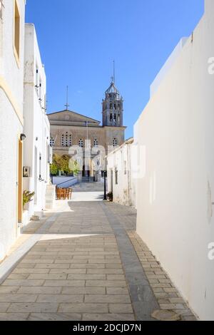 Schmale Straße in Lefkes Dorf auf Paros Insel. Kirche von Agia Triada im Hintergrund. Griechenland Stockfoto