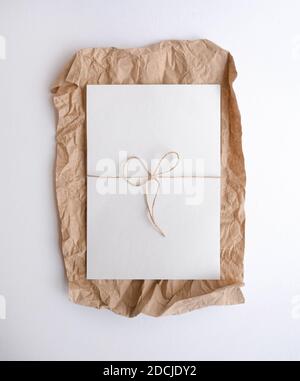 Weißes Blatt, das auf zerknittertem Papier liegt. Flatlay Stockfoto
