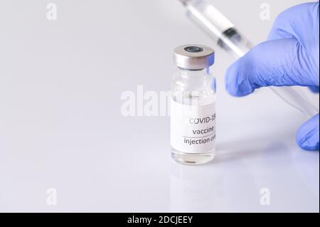 Arzt, der Medikamente aus Coronavirus-Impfstoffröhrchen abzieht Stockfoto
