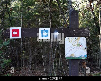 Farblich gekennzeichnete Pfeile und eine Karte - Wegweiser auf einem Wanderweg in der Nähe von Wakefield, Quebec, Kanada. Wir schaffen es immer noch, uns zu verlaufen. Stockfoto