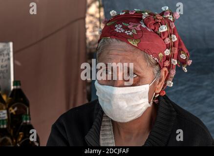 11/16/2020,Edremit,Balikesir,Türkei,Ansicht einer alten Straßenverkäufer Frau mit Pandemiemaske Stockfoto