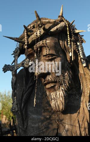 Holzstatue von Jesus Christus mit Rosenkranz und Kruzifix auf dem Kreuzberg bei Šiauliai in Litauen verziert. Der wichtigste litauische Wallfahrtsort befindet sich etwa 12 km von der Stadt Šiauliai entfernt. Niemand hat jemals versucht zu zählen, wie viele große und kleine Kreuze tatsächlich auf dem Hügel installiert sind, aber es wird angenommen, dass es hier mindestens zweihunderttausend Kreuze gibt. Und jeden Tag werden Dutzende oder sogar Hunderte von neuen Kreuzen von Pilgern aus der ganzen Welt hinzugefügt. Stockfoto