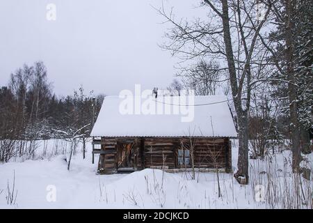 Altes Holzgebäude des Badehauses im Dorf im Wintertag. Traditionelles Äußeres im russischen Stil. Stockfoto