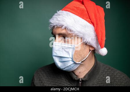 Mann in roten weihnachtsmann Hut und Gesichtsmaske Porträt Stockfoto