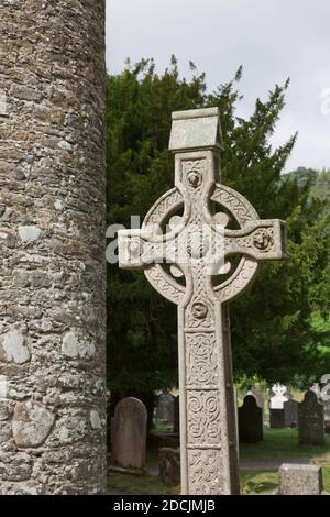 Steinrundturm und einige Ruinen einer Klostersiedlung, die ursprünglich im 6. Jahrhundert im Glendalough Valley, County Wicklow, Irland, erbaut wurde. Stockfoto