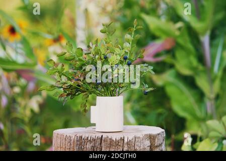 Bouquet von reifen Waldbluebeere und Preiselbeerpflanzen in der Holzvase. Stockfoto