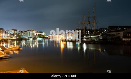 Die SS Großbritannien und moderne Wohngebäude werden nachts auf der regenerierten Hafenseite der Bristol Docks beleuchtet. Stockfoto