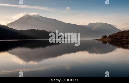 Der schneebedeckte Berg Beinn A'Bheithir erhebt sich hinter Loch Leven und bewaldet rund um Glencoe Dorf in den West Highlands von Schottland. Stockfoto